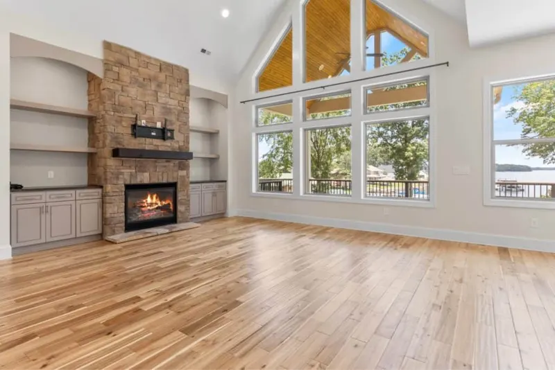 Vaulted great room with stone fireplace and lake-view windows