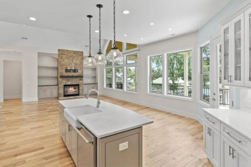 Bright kitchen with white island and pendant lights