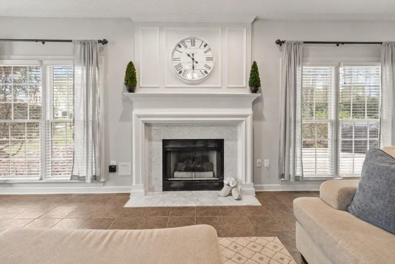 Living room with white mantel fireplace and wall clock
