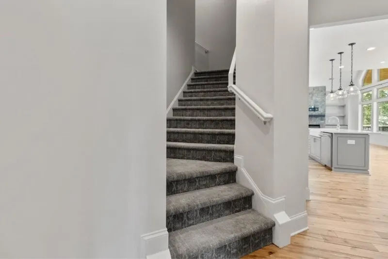 Modern staircase with carpeted treads and white rails