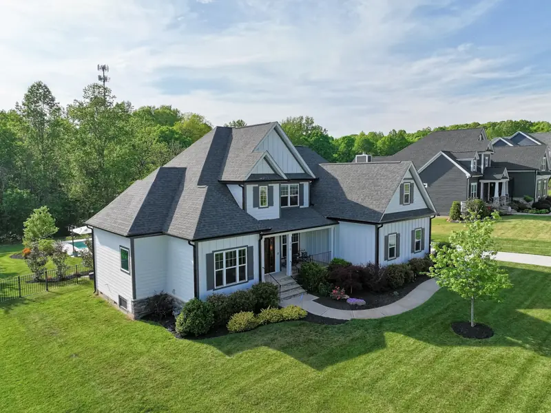Low drone view of a two-story craftsman home and yard