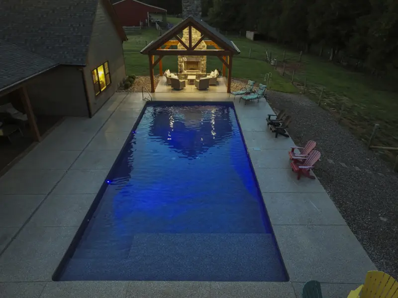 Overhead drone view of a lit pool at night