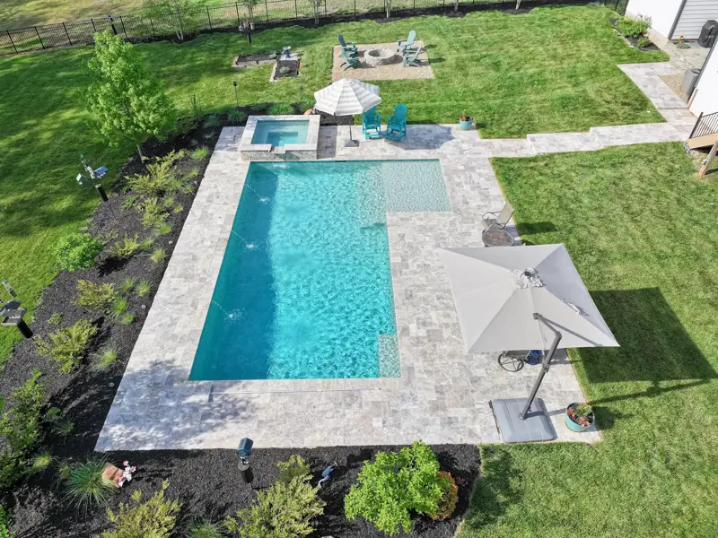 Overhead drone view of a backyard pool and patio