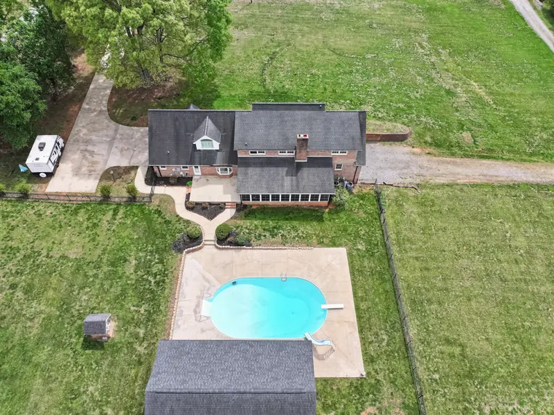 Aerial view of a brick home with a kidney-shaped pool