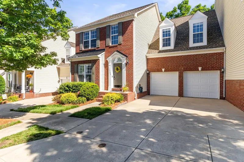 Brick townhome with double garages on a tree-lined street