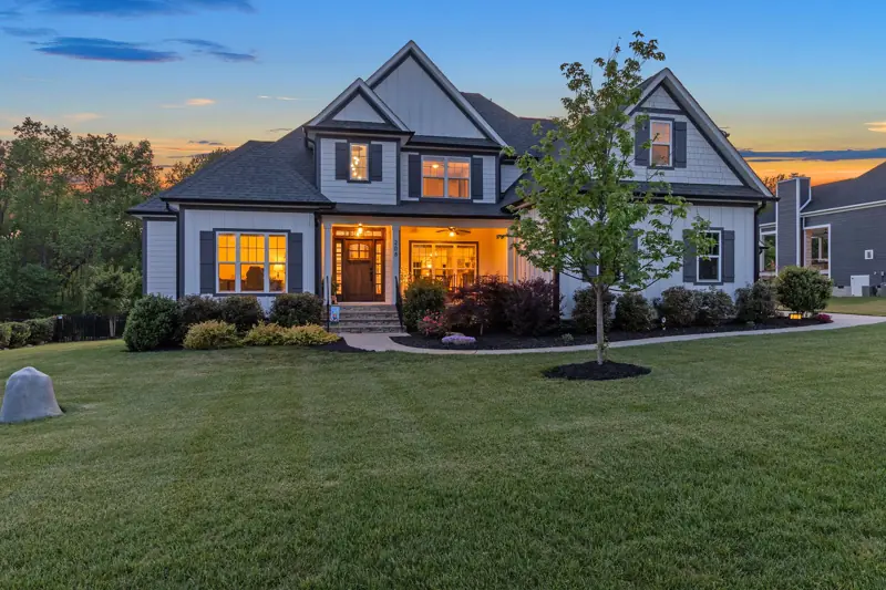 Craftsman home at twilight with warm interior lights