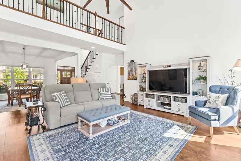 Bright great room with stone fireplace and open loft above