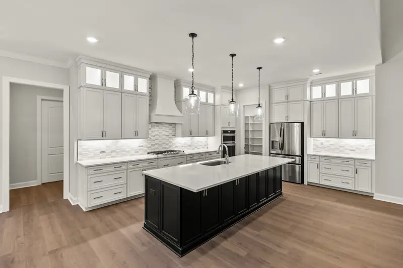 New construction kitchen with black island and white cabinetry