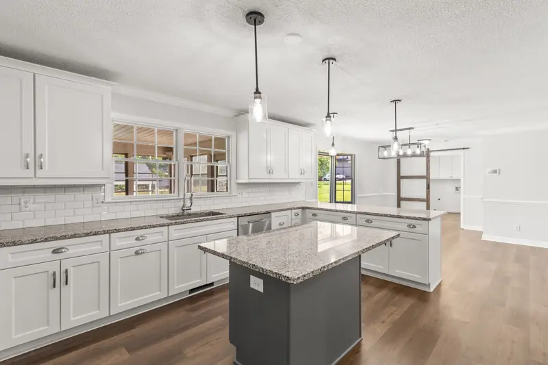White kitchen with gray island and pendant lights