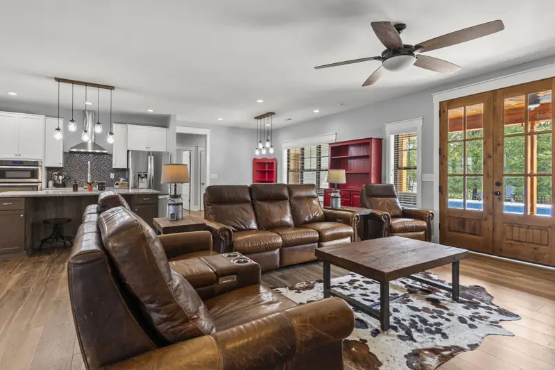 Open living room with leather sofas and French doors