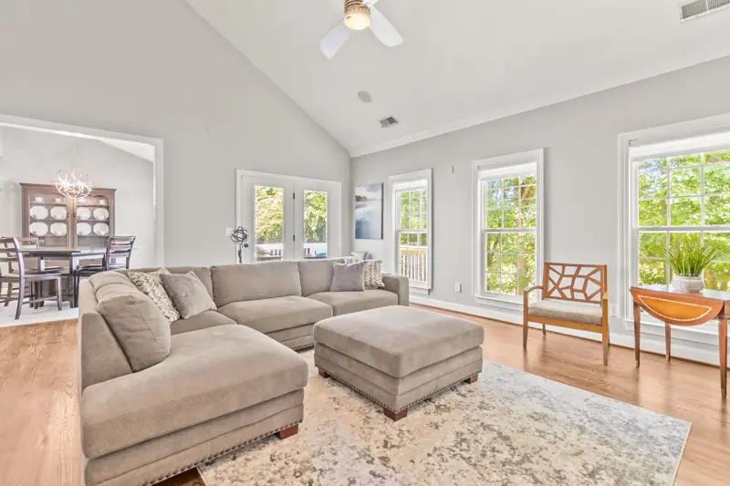 Vaulted living room with sectional sofa and stone fireplace